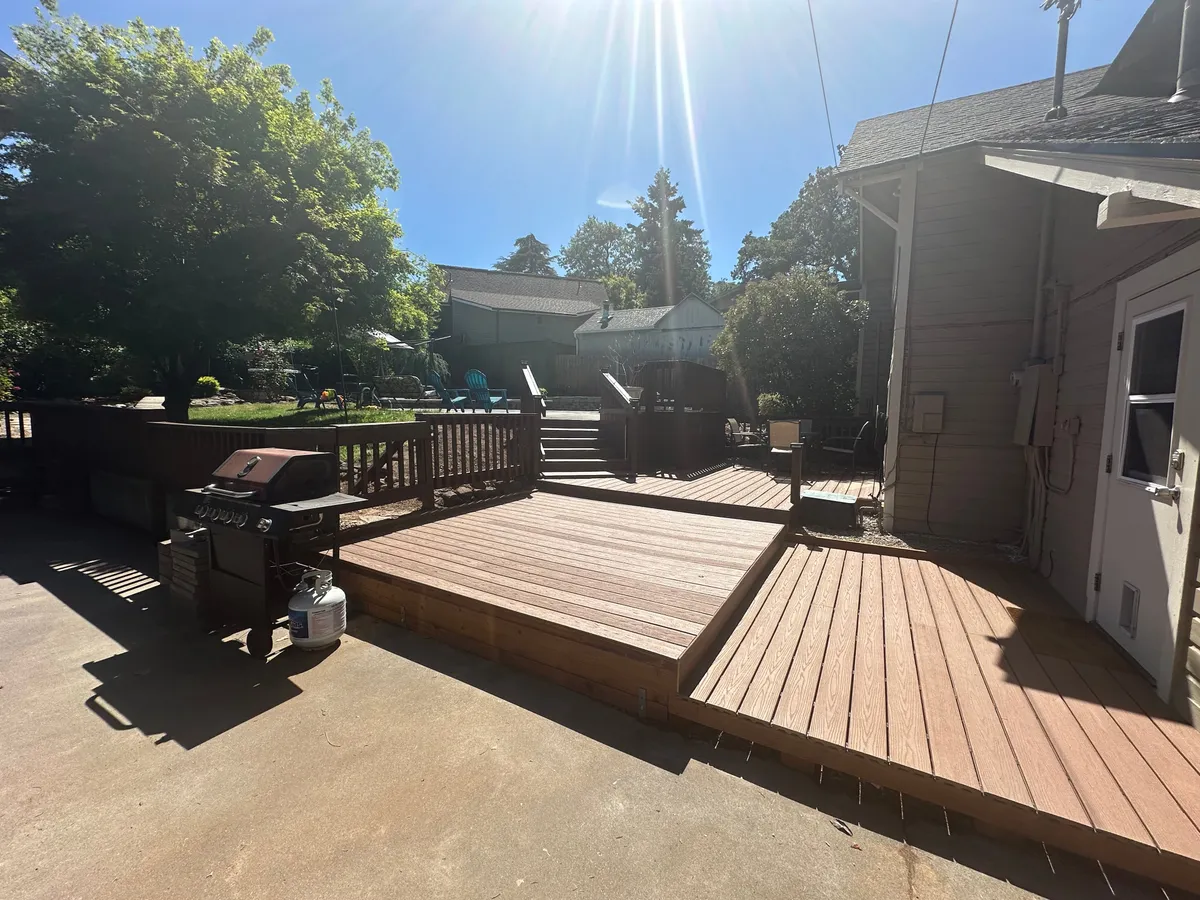 This exterior shot captures a cheerful deck area equipped with a grill, comfortable seating, and a spacious lawn. The area is perfect for outdoor dining, social gatherings, or simply relaxing after exploring the city. The image exudes a welcoming, community-focused vibe, aligning with the idea of enjoying local cuisine or home-cooked meals in a pleasant outdoor setting.